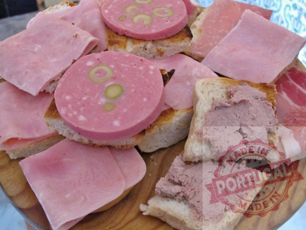 Mixed appetizer board with ham, mortadella, and pate | Mixed antipasto board featuring various toasted bread slices with cold cuts and spread - Realisiert mit Pictrs.com