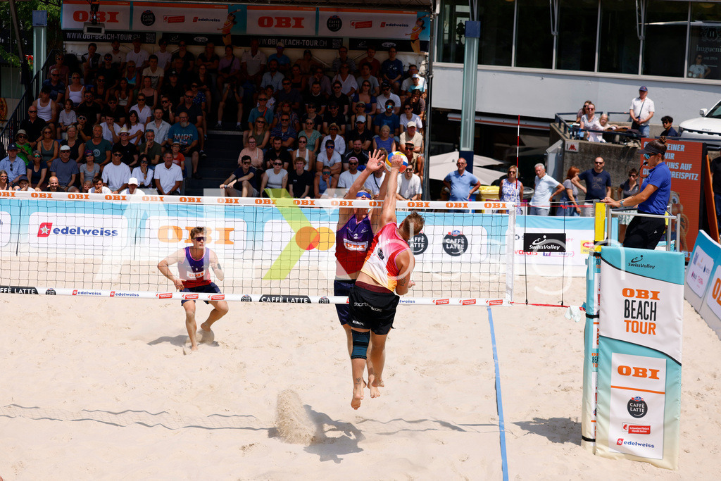 Obi BeachTour 2026 - Basel | BASEL, SWITZERLAND - JULY 19: MORITZ KINDL (AUT) attack / spike against MATHIS KÄLIN (SUI) block during the Obi BeachTour 2026 match between LEITNER / KINDL (AUT) and BREER / KÄLIN (SUI) at Barfüsserplatz on July 19, 2026 in Basel, Switzerland. - Realisiert mit Pictrs.com
