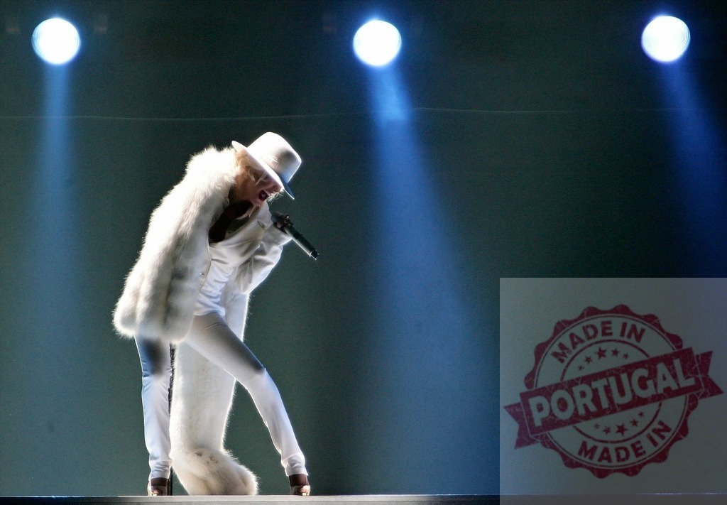 Christina Aguilera singing on stage wearing white suit and fur during a concert | Christina Aguilera performing live on stage, wearing white clothes and holding a microphone - Realized with Pictrs.com