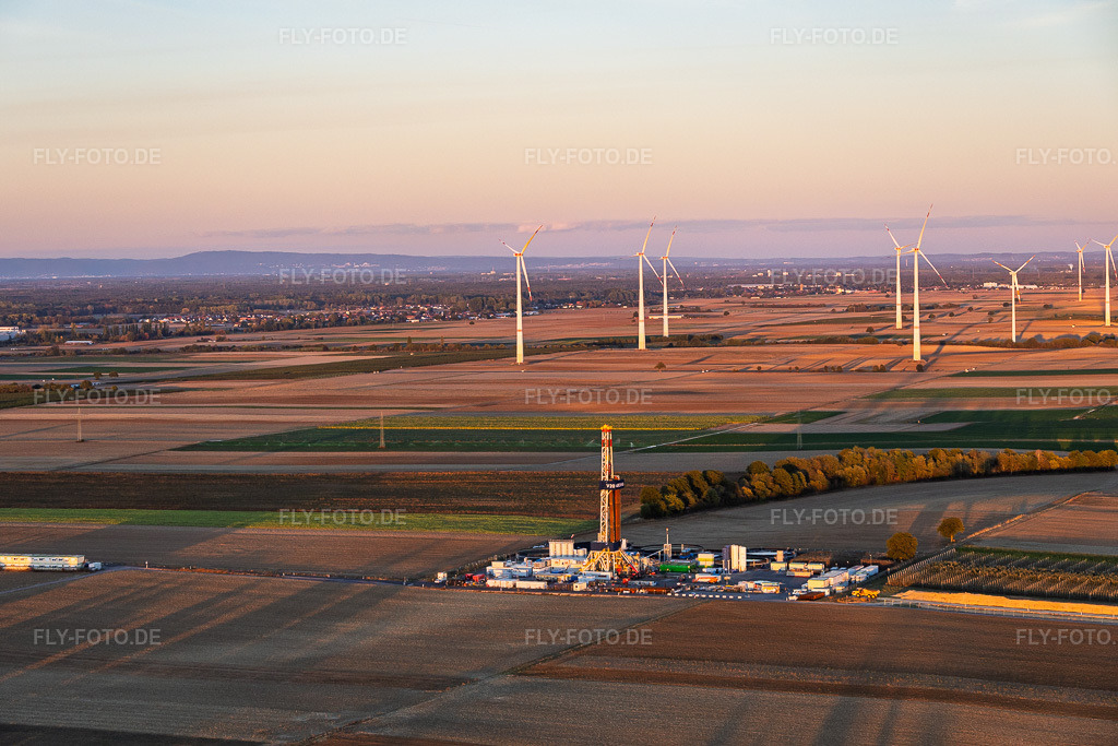 Luftbild: Tiefenbohrplatz Rig V20 - Vercana von Vulcan Energy vor dem Windpark Offenbach im Abendlicht am Schleidberg zur Förderung von Geothermie und Lithium in Insheim im Bundesland Rheinland-Pfalz in Deutschland. – Foto: IMG_159920.jpg vom 12.10.2026 durch Werner Riehm/FLY-FOTO.de – Auflösung des Originals: 5643 x 3762 px – VULCAN ENERGY RESOURCES