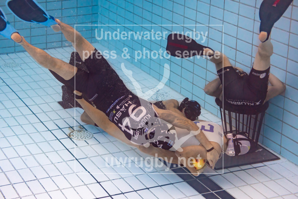 24. - 26.11.2023: Unterwasser-Rugby Champions Cup 2023  | Spielstart im Vorrunden-Spiel HäSu (Finnland) in blau gegen SDK Malmö Triton  (Schweden) in weiß. Jesper  Larsson vom schwedischen Meister Malmö in weiß mit der Nummer 3 wird kurz vorm finnischen Tor von Hannu Kuukauppi (blau mit der Nummer 94) gestoppt. - Realisiert mit Pictrs.com