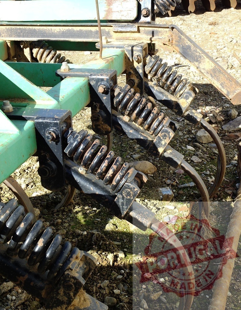 Cultivator machine tines with springs for farming | Cultivator tines displaying metal springs and agricultural machinery details - Realized with Pictrs.com
