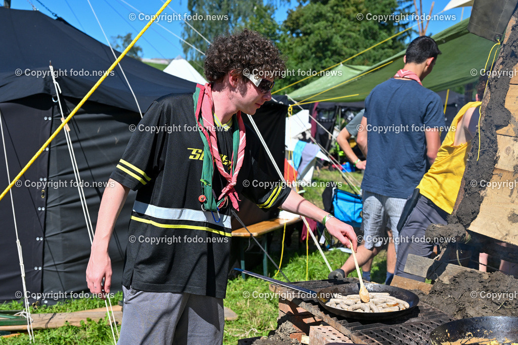 Scout Camp Austria_ 11.08.2023-42 | 11.08.2023, Berg am Attersee, AUT, Scout Camp Austria 2023, im Bild ein Pfadfinder an der Kochstelle beim Wuerstchen grillen