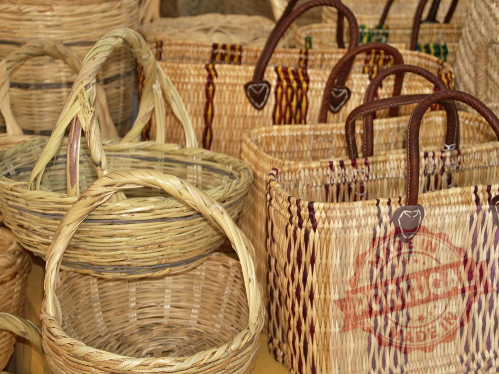 Handcrafted woven straw baskets and market bags displaying traditional craft | Wicker and straw baskets with decorative patterns and leather handles for sale - Realisiert mit Pictrs.com