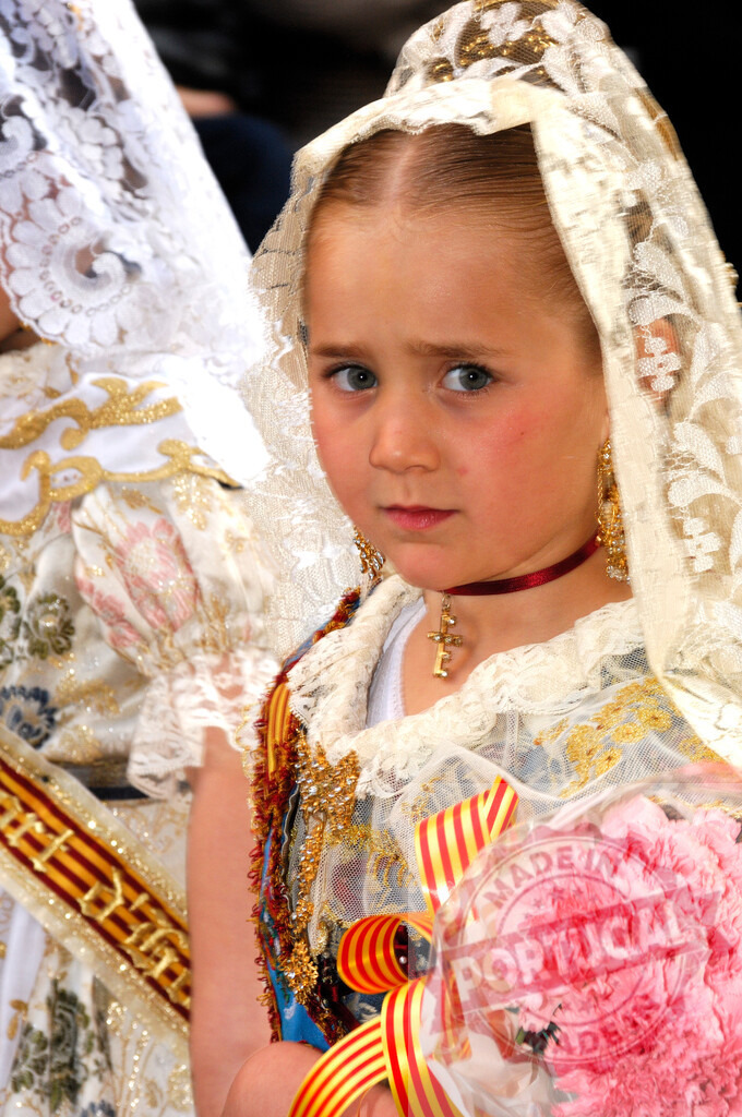 Young girl celebrating Las Fallas in traditional costume | Young girl holding pink flowers, wearing traditional Fallera costume and mantilla during Las Fallas - Realisiert mit Pictrs.com