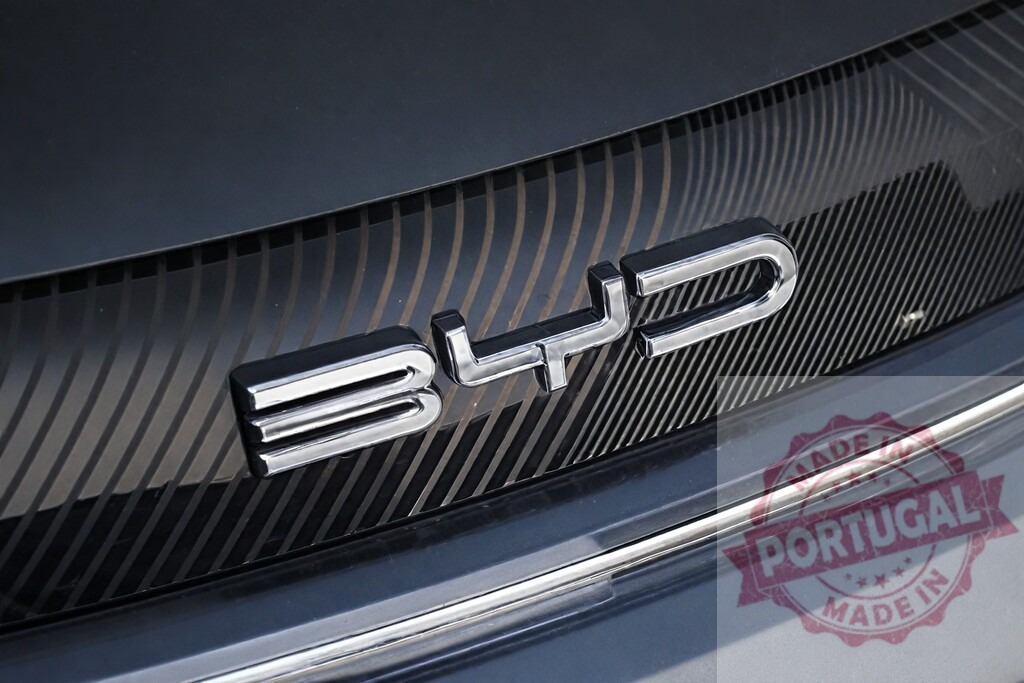 BYD logo on electric vehicle grill design | BYD chrome emblem on car front grill with patterned background - Realized with Pictrs.com