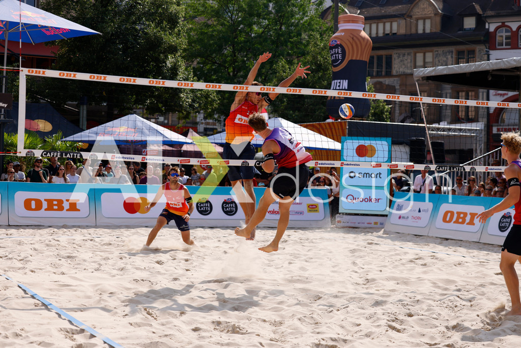 Obi BeachTour 2026 - Basel | BASEL, SWITZERLAND - JULY 19: FLORIAN BREER (SUI) attack / spike against LUC EMANUEL FLÜCKIGER (SUI) block during the Obi BeachTour 2026 match between DILLIER / FLÜCKIGER (SUI) and BREER / KÄLIN (SUI) at Barfüsserplatz on July 19, 2026 in Basel, Switzerland. - Realisiert mit Pictrs.com