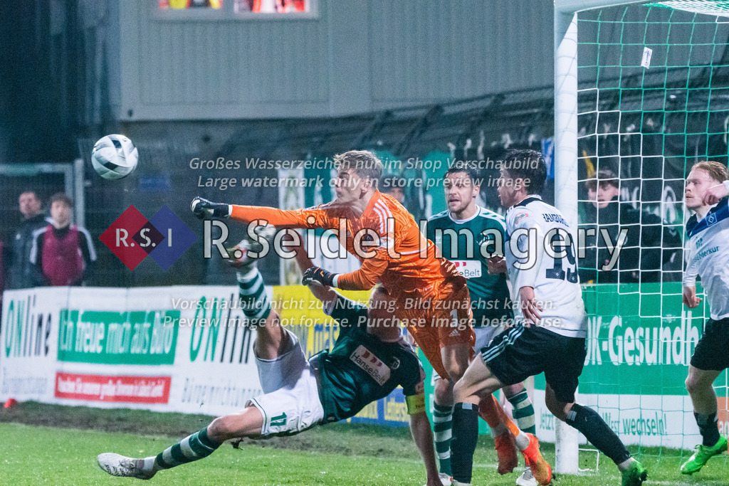 Fußball, Saison 2022/23, Regionalliga Nord, VfB Lübeck - Hamburger SV II, Stadion an der Lohmühle (Lübeck), 25.11.2022, 20. Spieltag | Leo Oppermann (#1, HSV II, Torwart) faustet den Ball aus dem Torraum, bevor Tommy Grupe (#17, Lübeck, Teamkapitän) per Fallrückzieher erwischen kann.