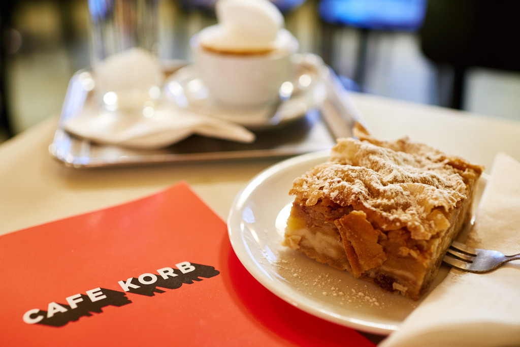Cafe Korb | Wien, Austria - January 28, 2019: Cafe Korb; eine Melange und ein Apfelstrudel mit einer roten Speisekarte auf dem Tisch. - Realisiert mit Pictrs.com