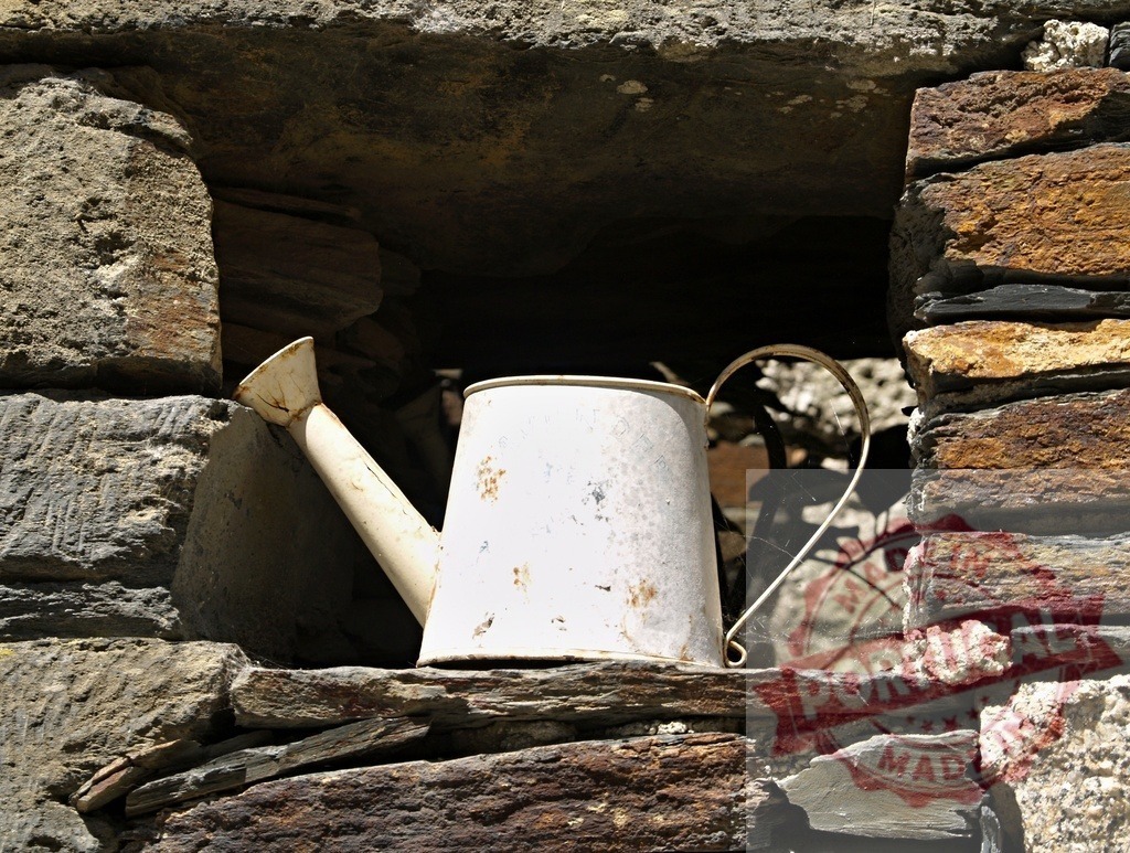 Old white watering can on rustic stone wall | Vintage watering can sitting in a niche of an ancient stone wall on a sunny day - Realisiert mit Pictrs.com