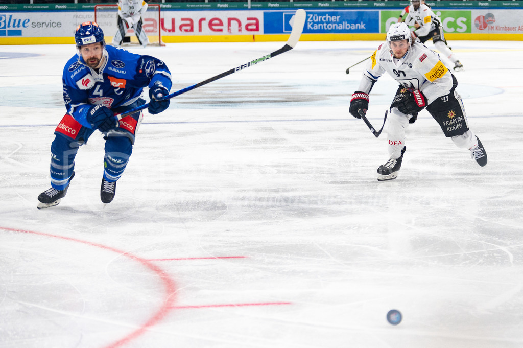 Swiss National League: Semifinals Game 4: ZSC Lions - Fribourg-Gotteron | 14.04.2022, Zürich, Hallenstadion, Swiss National League: Semifinals Game 4: ZSC Lions - Fribourg-Gotteron, #4 Patrick Geering (ZSC) und #97 Nathan Marchon (Fribourg) sprinten dem Puck nach. - Realisiert mit Pictrs.com