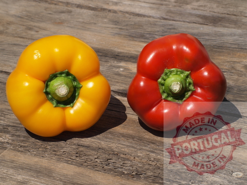 Yellow and red bell peppers on wooden table | Fresh yellow and red bell peppers sitting on a rustic wooden surface - Realisiert mit Pictrs.com