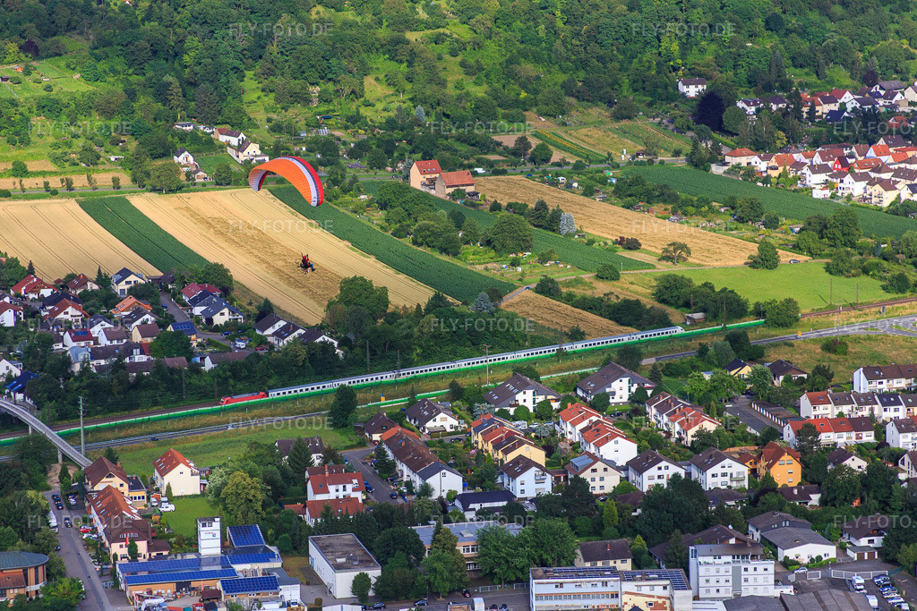 Luftbild: Paragleiter über einem Personenzug auf den Gleisen längs der Draisstr in Hemsbach im Bundesland Baden-Württemberg in Deutschland. Foto: IMG_090673.jpg vom 04.07.2016 durch Werner Riehm/FLY-FOTO.de