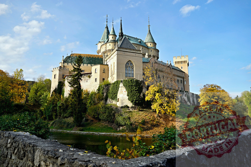 Bojnice Castle in Slovakia during autumn season | Bojnice Castle with its iconic spires reflecting in the moat on a clear autumn day - Realized with Pictrs.com
