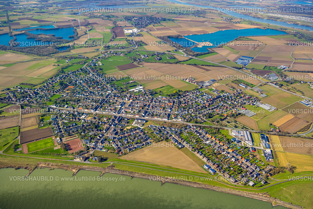 Wesel240310792Buederich | Luftbild, Wohngebiet Ortsansicht Ortsteil Büderich mit Venloer Straße, Innenstadt mit kath. Pfarrkirche St. Peter und Baustelle und Umbau mit Straßenbauarbeiten am Marktplatz, Umland mit Wiesen und Feldern, Hülskens Kieswerk und See, Feuchtgebiet bei Menzelen-Ost Landschaftsschutzgebiet, Büderich, Wesel, Nordrhein-Westfalen, Deutschland