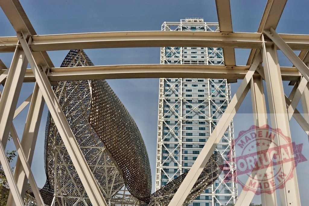 Peix sculpture and Hotel Arts building in Barcelona. Spain - Barcelona | Iconic Frank Gehry fish sculpture with a modern skyscraper in a Spanish urban landscape - Realized with Pictrs.com