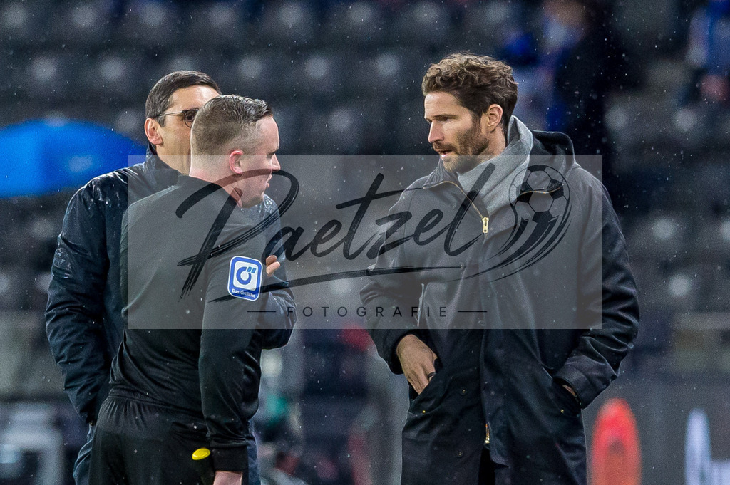 BSCRBL20220220_185 | Fussball, Herren: Schiedsrichterassistent Sascha Thielert spricht mit Sportdirektor Arne Friedrich (Hertha BSC) bei dem Spiel der 1. Bundesliga zwischen Hertha BSC und RB Leipzig im Olypiastadion am 20.02.2022 in Berlin, Deutschland.DFB / DFL REGULATIONS PROHIBIT ANY USE OF PHOTOGRAPHS AS IMAGE SEQUENCES AND/OR QUASI-VIDEO. - Realisiert mit Pictrs.com