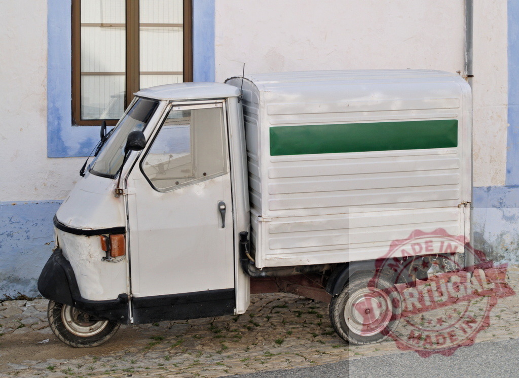 Small white three-wheeled delivery truck parked near a blue and white building | Small white three-wheeled delivery truck parked near a blue and white building, with a green stripe on its side - Realisiert mit Pictrs.com