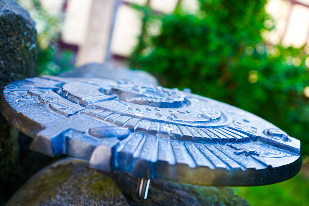 Ufo - Eckartsborn | In der Ortsmitte des Eckartsborner Oberdorfs vermischt sich gelebte Sciencefiction mit der urhessischen Realität. Wer sich den liebevoll gestalteten Platz ansieht, wird auf eine Zeitreise durch die Epochen geführt. Die Baumaterialen Stein und Holz werden im Laufe der Jahrhunderte mit schmiedeeisernen Werkstücken ergänzt. Interessierte finden an diesem unwahrscheinlichen Platz sogar ein Zeugnis der menschlichen Exploration des Weltalls. - Realisiert mit Pictrs.com