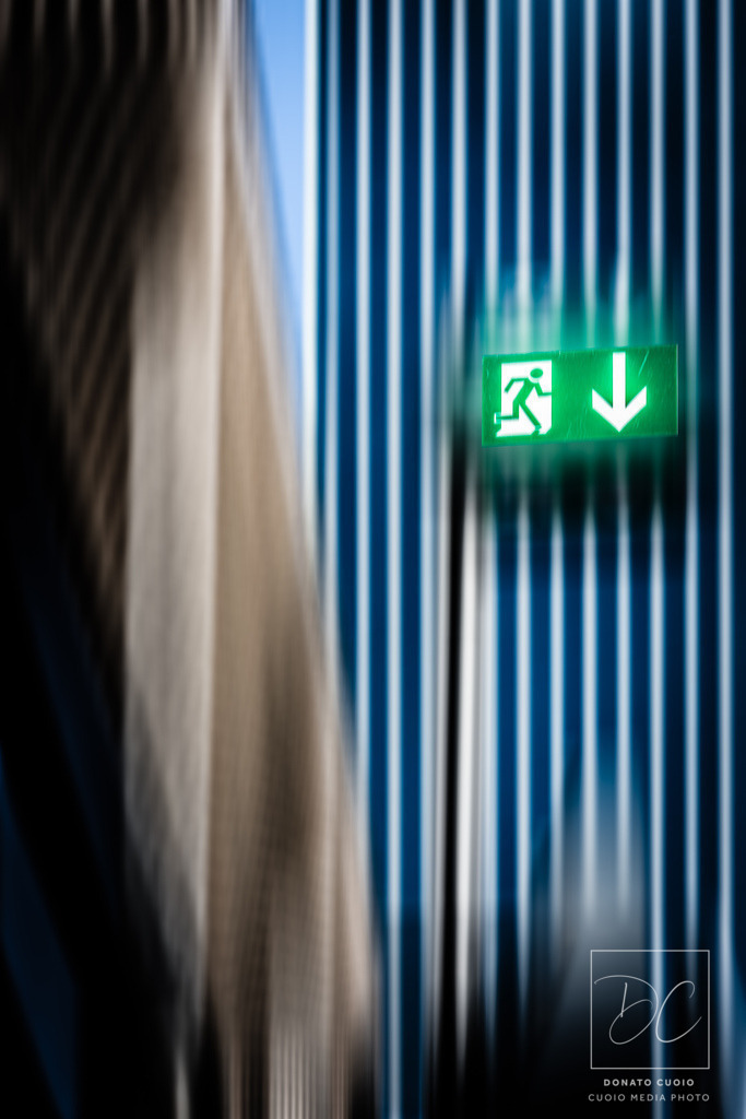Notausgang | Das Bild zeigt eine Szene, in der ein Notausgangsschild im Fokus steht, während die Umgebung durch Bewegungsunschärfe verschwommen dargestellt ist. Diese künstlerische Umsetzung symbolisiert den oft erst spät erkannten Ausweg aus chaotischen Situationen und lädt den Betrachter ein, über die Bedeutung von Fluchtwegen im übertragenen Sinne nachzudenken.Durch den gezielten Einsatz von Bewegungsunschärfe und digitale Bearbeitung wird die Dramatik und Symbolik eines Notausgangs inmitten von Unschärfe hervorgehoben. Dieses Kunstwerk spricht besonders diejenigen an, die eine tiefere Bedeutung in ihrer Wanddekoration suchen und moderne, symbolträchtige Kunst schätzen. - Realisiert mit Pictrs.com