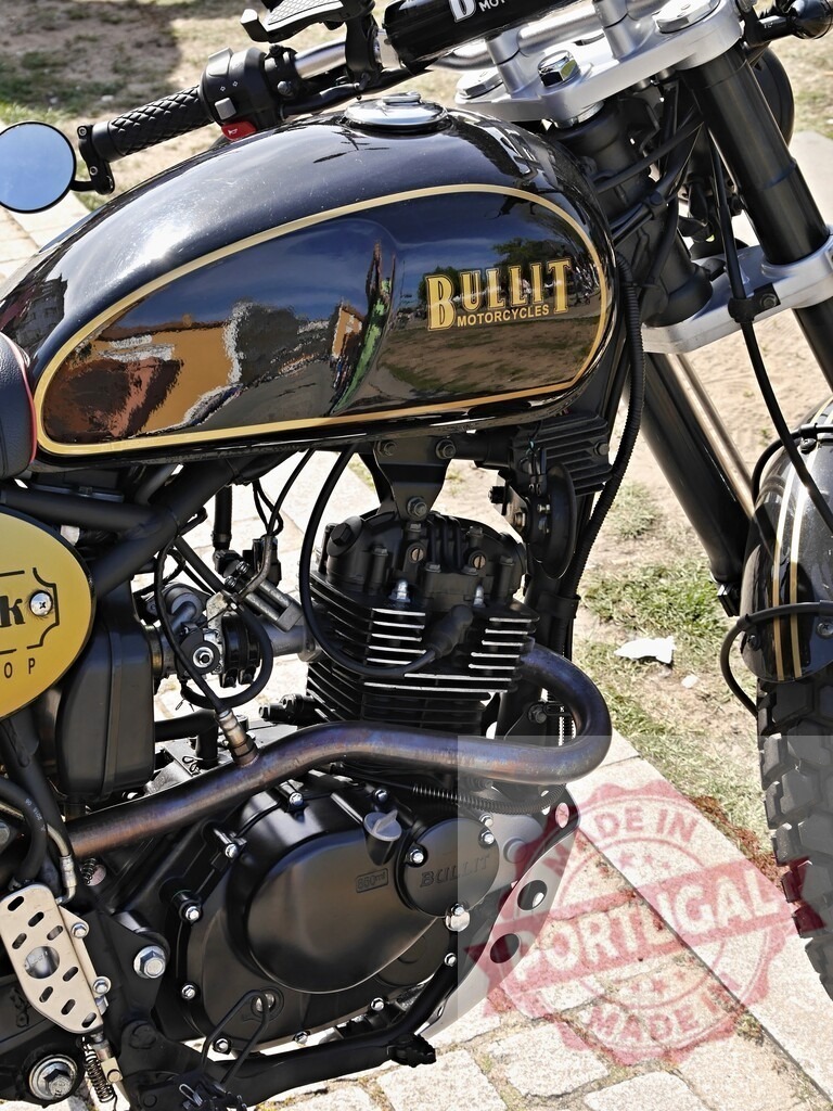 Bullit motorcycle engine and fuel tank reflecting surrounding buildings | Close-up of a Bullit motorcycle engine and fuel tank, reflecting surrounding buildings, showcasing its design and craftsmanship - Realized with Pictrs.com