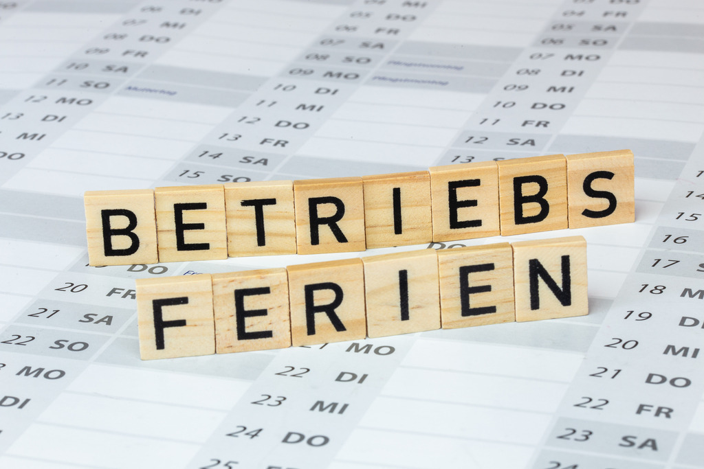 BETRIEBSFERIEN Holzbuchstaben auf einem Kalender | BETRIEBSFERIEN Holzbuchstaben auf einem Kalender - Realisiert mit Pictrs.com