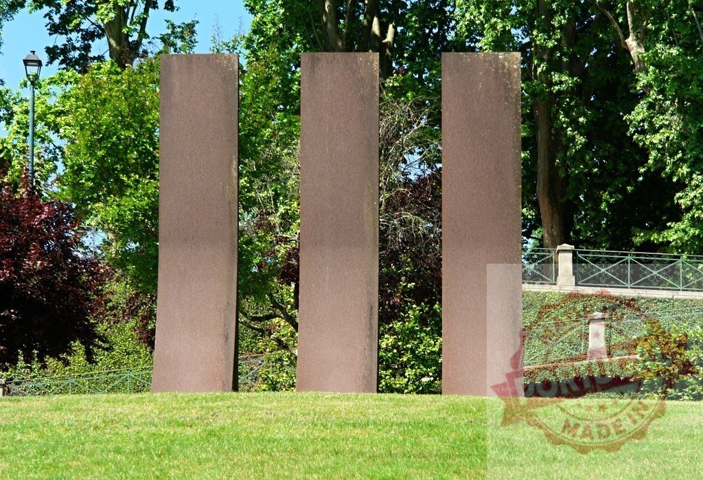 Three vertical minimalist steel sculptures standing in a park. Region Norte - Portugal | Three weathering steel monoliths creating a minimalist art installation in a green park - Realisiert mit Pictrs.com