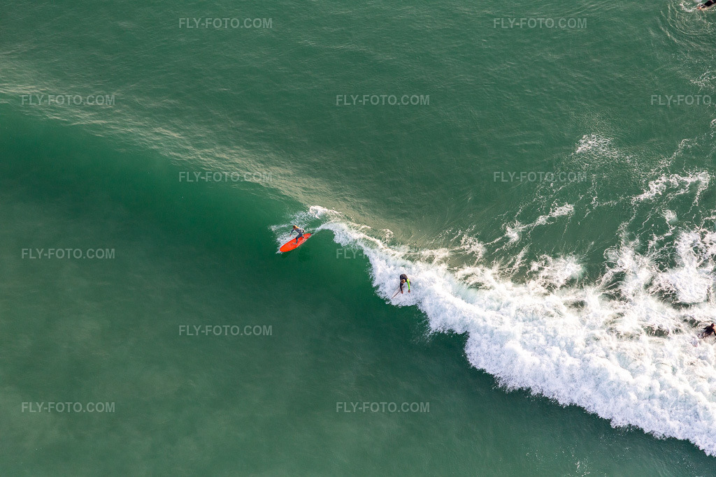 Aerial view: Wave surfers in front of the Plage de Tronoën in Saint-Jean-Trolimon in the state Finistere, France. – Photo: IMG_132563.jpg taken on 06/17/2022 by Werner Riehm/FLY-FOTO.com – Resolution of the original: 5472 x 3648 px