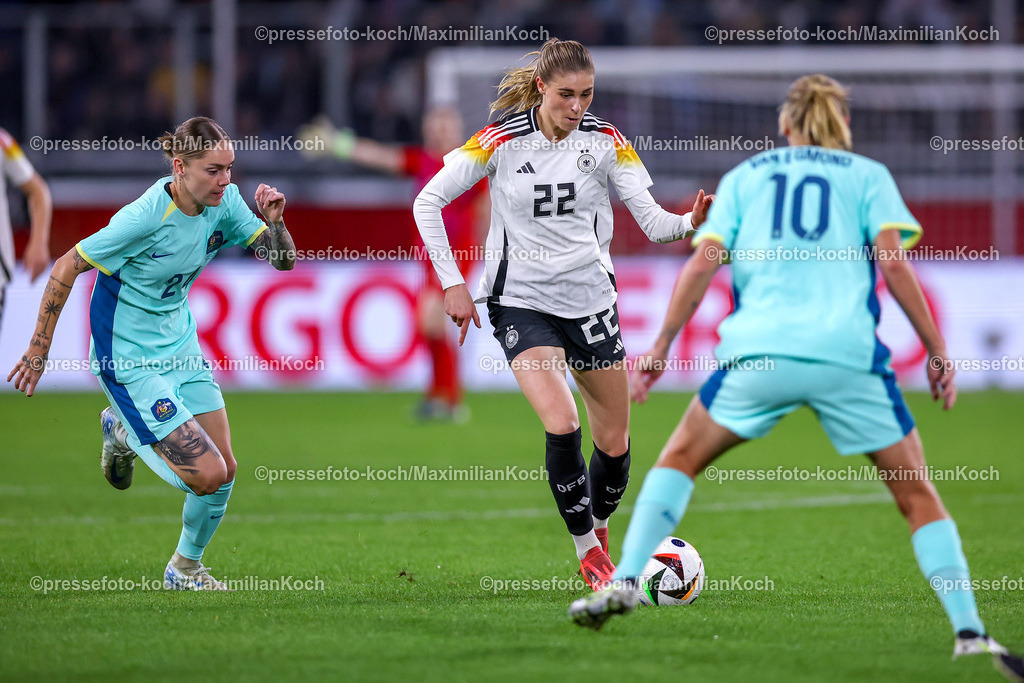 DFB28102401060 | 28.10.2024, Fußball Länderspiel Frauen, Deutschland - Australien, Schauindland-Reisen-Arena Duisburg, Saison 2024 2025: Jule Brand (GER #22) im Kampf um den Ball gegen Sharn Freier (AZN #24) und Emily van Egmond (AZN #10)