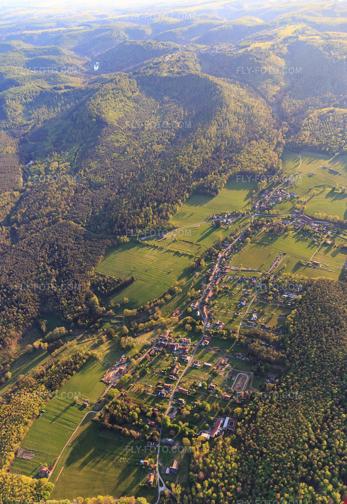 Aerial view: Village view in a forest clearing in the Northern Vosges Mountains from the northeast. in Erckartswiller in the state Bas-Rhin, France.Photo: IMG_145830.jpg taken on 04/30/2025 by Werner Riehm/FLY-FOTO.comResolution of the original: 3295 x 4777 px