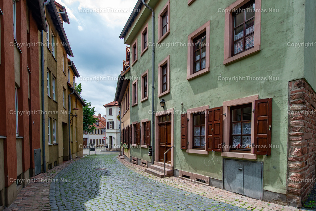 _DSC1470 | Wikipedia: Die Judengasse lag am nördlichen Rand der mittelalterlichen Kernstadt. Die Häuser der Nordseite nutzten die innere Stadtmauer als Rückwand. Die Judengasse bestand im weiteren Sinn aus zwei Straßen:Der Judengasse, die zwischen Martinspforte und Bärengasse parallel zum nordöstlichen Abschnitt der Stadtmauer verlief. Sie war an beiden Enden durch Tore von der übrigen Stadt getrennt. Das südöstliche war die Judenpforte. Sie führte durch die Mauer direkt zum Rhein und wurde beim Wiederaufbau nach der Stadtzerstörung 1689 vermauert. Nach der Öffnung des Ghettos wurde sie wieder geöffnet und führte im 19. Jahrhundert zeitweise die Bezeichnung Hamburger Tor. Auf der anderen Seite war die Judengasse im Westen mit einem Tor zur heutigen Friedrichstraße abgegrenzt. Das Raschitor, ein Durchbruch durch die Stadtmauer nach Norden, zum heutigen Berliner Ring, und die Karolingerstraße, die die Judengasse heute kreuzt, entstand erst 1907/08.[1]Der Hinteren Judengasse, die im rechten Winkel auf dem Platz vor der Synagoge auf die Judengasse stößt. Vor Anlage der Karolingerstraße mündete sie mit ihrem anderen Ende wieder in den östlichen Bereich der Judengasse.[2],, Bild: Thomas Neu
