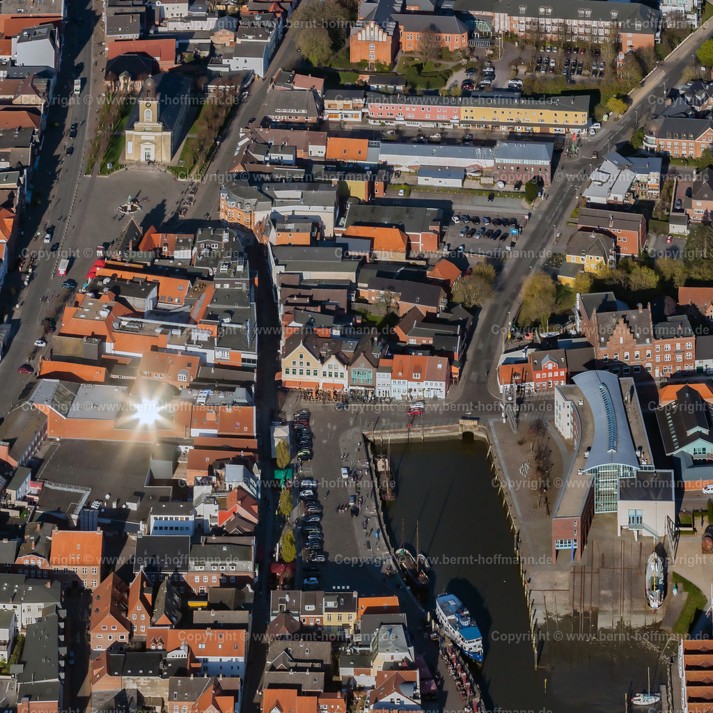 PLB_0462mod_Husum_REFLEX_100x100 | LUFTBILD. Husumer Altstadt mit Innenhafen. __ Zentrum der nordfriesischen Stadt Husum. Am Hafen ( ganz rechts ) das Rathaus in einer ehemaligen Schiffswerft. Der Sonnenlicht-Reflex in einem Dachfenster konnte zufällig fotografisch eingefangen werden, gibt dem Bild aber eine besondere Note. - Realisiert mit Pictrs.com