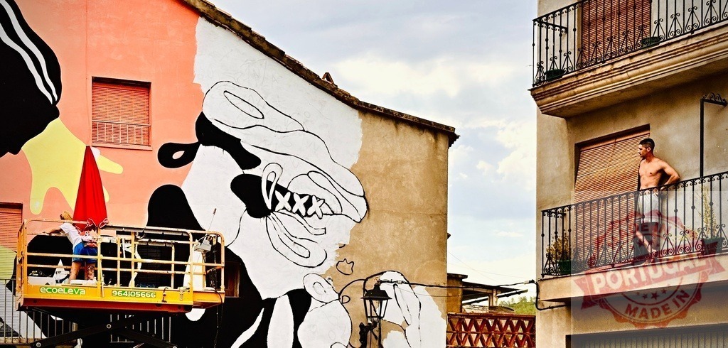 Artist painting large street art mural with cherry picker | Artist using a cherry picker to paint a black and white mural on an urban building wall - Realisiert mit Pictrs.com