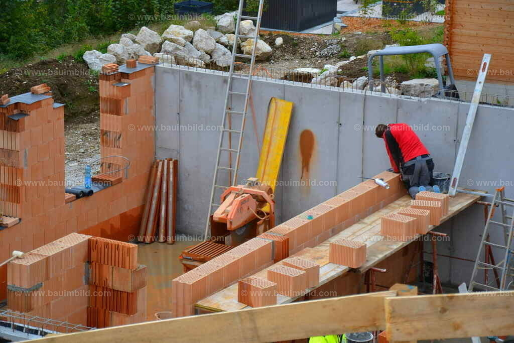 Mauerarbeiten Ziegelmauerwerk | Maurer beim Mauern von Mauerwerk aus Ziegeln zwischen Betonwänden