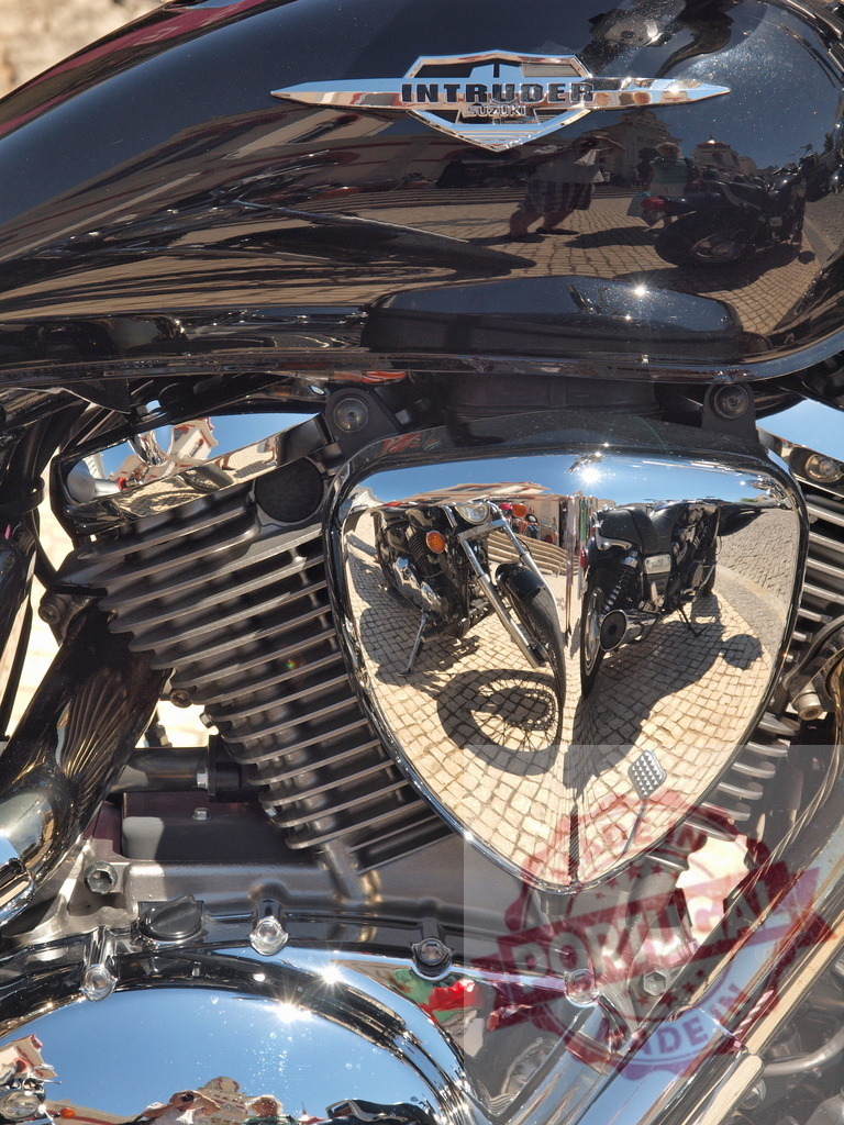 Suzuki Intruder motorcycle engine gleaming with chrome reflections | Close-up of Suzuki Intruder motorcycle engine featuring shiny chrome and detailed reflections - Realisiert mit Pictrs.com