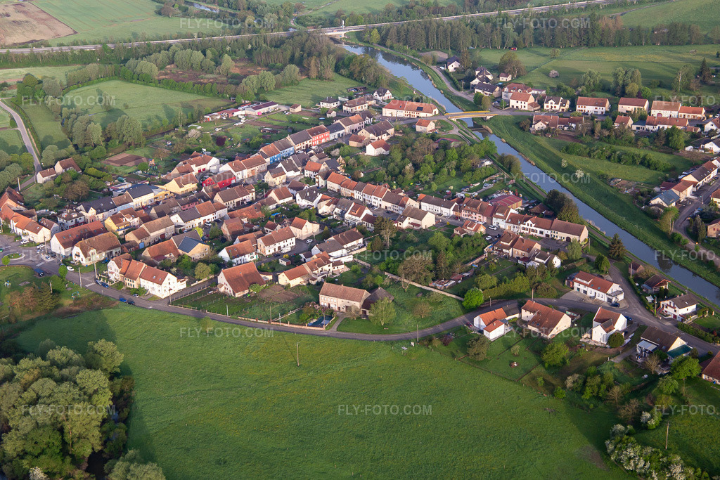 Aerial view: Rue des Mures and Canal des Houillères de la Sarre in Herbitzheim in the state Bas-Rhin, France. – Photo: IMG_140546.jpg taken on 05/01/2024 by Werner Riehm/FLY-FOTO.com – Resolution of the original: 5116 x 3411 px
