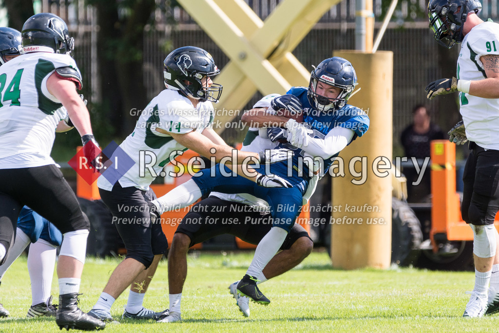 American Football, Saison 2022, Regionalliga Nord, Hamburg Blue Devils - Oldenburg Knights, Dr.-Hermann-Schnell-Sportplatz (Hamburg), 06.08.2022, 07. Gameweek | Ikenna Ukachu (#5, Oldenburg, DB) und Timo Löffler (#14, Oldenburg, DB) tackeln Jan-Niklas Zibull (#39, Blue Devils, RB).