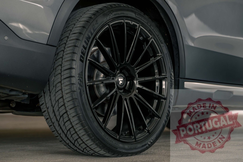 Car wheel with black alloy rim and Delinte tire | Car wheel featuring a modern black multi-spoke alloy rim and a Delinte performance tire - Realisiert mit Pictrs.com