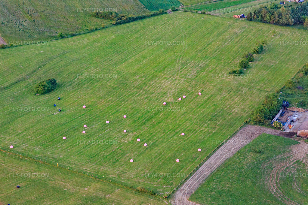 Aerial view: Mowed meadow with round hay bales in Bining in the state Moselle, France. – Photo: IMG_107424.jpg taken on 05/19/2018 by Werner Riehm/FLY-FOTO.com – Resolution of the original: 4755 x 3170 px