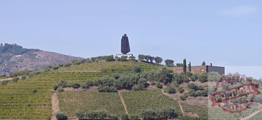 Sandeman Don statue overlooking Douro Valley vineyards | The iconic Sandeman Don statue stands on a hill surrounded by terraced vineyards in the Douro Valley - Realized with Pictrs.com
