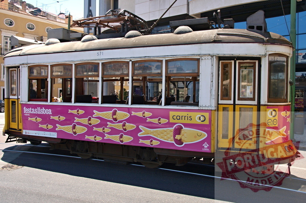 Vintage Lisbon Tram Promoting Festas de Lisboa with Sardines | Yellow and white vintage Lisbon tram promoting Festas de Lisboa with sardines advertisement, parked on a sunny day - Realized with Pictrs.com