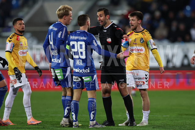 TSV Egger Glas Hartberg vs SV Oberbank Ried – Austrian Bundesliga Match | The image shows Benjamin Markus (Hartberg), Juergen Heil (Hartberg), referee Safak Barmaksiz and Philipp Pomer (Ried) have a discussion, at the Bundesliga match TSV Hartberg vs SV Ried at Profertil Arena Hartberg. 22.11.2025