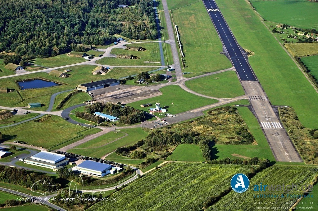 Luftbild Flughafen Husum-Schwesing - Nach dem Krieg wurde der Flugplatz von der British Air Force of Occupation (BAFO) ab 1947 instandgesetzt | Nach dem Krieg wurde der Flugplatz von der British Air Force of Occupation (BAFO) ab 1947 instandgesetzt und zu einem vollwertigen Militärflugplatz ausgebaut, ohne dass jedoch fliegende RAF-Verbände stationiert wurden. Die Aufstellung des Jagdbombergeschwaders 35, das später in LeKG 41 umbenannt wurde, erfolgte in Teilen ab dem 1. Dezember 1958 in Faßberg und ab dem 1. Februar 1959 in Nörvenich. Zum 1. Oktober 1959 erfolgte die Zusammenlegung am Fliegerhorst Husum. Als erstes Flugzeugmuster erhielt der Verband 49 F-84F „Thunderstreak“ sowie 4 Lockheed T-33A zur Schulung. Die NATO-Assignierung erfolgte am 1. August 1961.