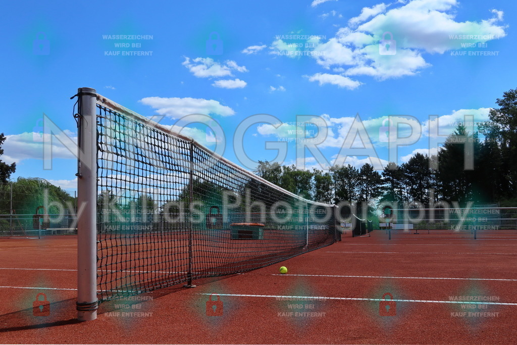 Tennismoment | Ein Tennisball liegt vor dem Tennisnetz auf dem Court.