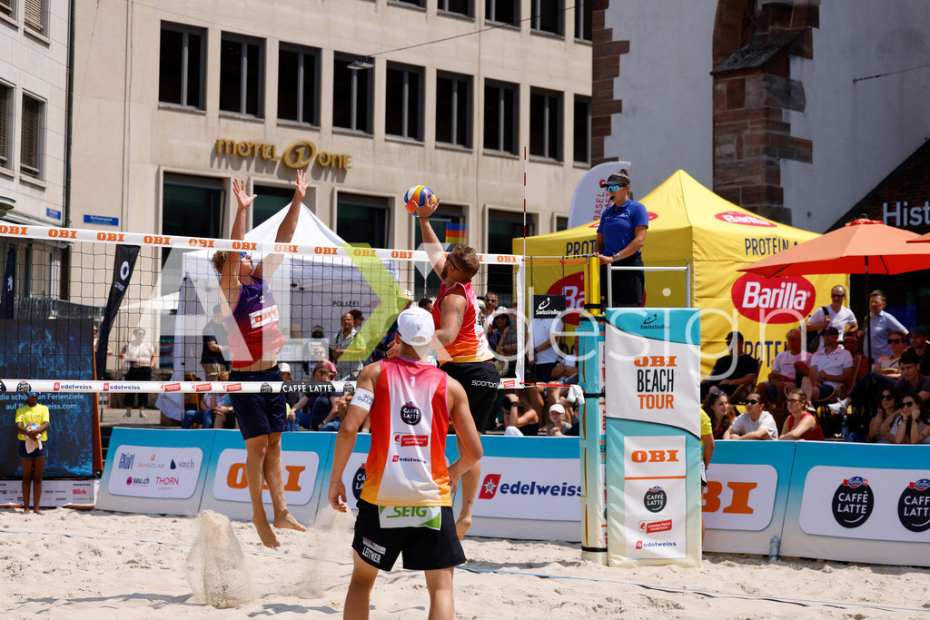 Obi BeachTour 2026 - Basel | BASEL, SWITZERLAND - JULY 19: MORITZ KINDL (AUT) attack / spike against MATHIS KÄLIN (SUI) block during the Obi BeachTour 2026 match between LEITNER / KINDL (AUT) and BREER / KÄLIN (SUI) at Barfüsserplatz on July 19, 2026 in Basel, Switzerland. - Realisiert mit Pictrs.com