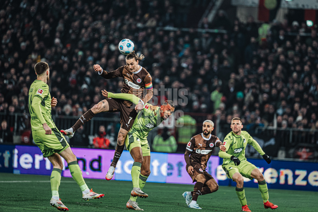 Fußball | Männer | Saison 2024/2025  | Fußball-Bundesliga | 26. Spieltag | FC St. Pauli vs. TSG Hoffenheim | 14.03.2025 | v.l. Kopfballduell zwischen Jackson Irvine (#7, FC St. Pauli) und Kevin Akpoguma (#25, TSG Hoffenheim)