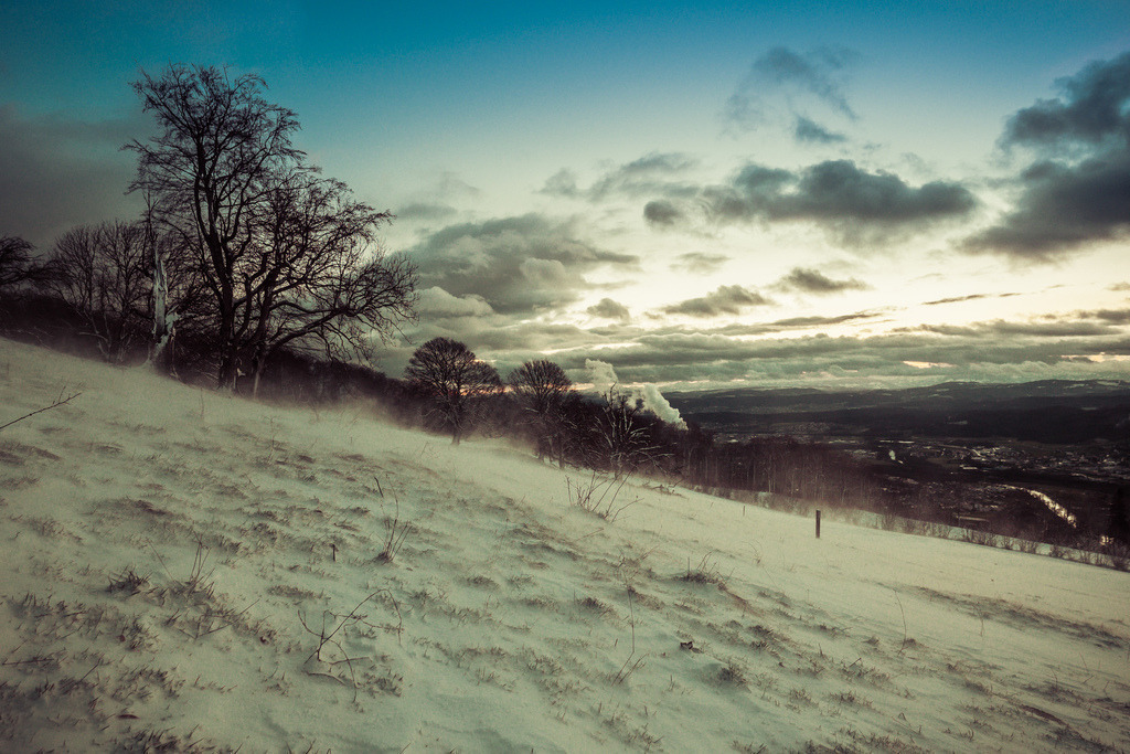 Winterliche Stimmung am Morgen auf der Froburg | Eisiger Wind zieht über das Feld mit gefrorenem Schnee und wirbelt Schnee auf - Realisiert mit Pictrs.com