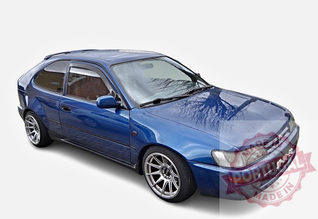 Tuned Toyota Corolla E10 lifting its hood showing alloy rims and rain reflection | Customized blue Toyota Corolla E10 parked after the rain, reflecting trees on its hood - Realisiert mit Pictrs.com