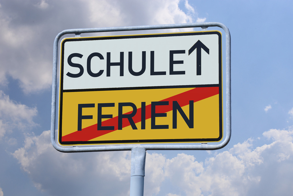 SCHULE und FERIEN auf einem Ortsschild | Symbolbild Schulstart: Auf einem Ortsausgangsschild stehen die Worte SCHULE und FERIEN - Realisiert mit Pictrs.com