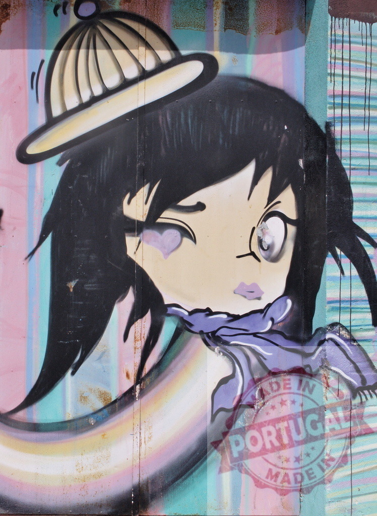 Winking cartoon girl with yellow beanie hat and purple scarf painted on a colorful wall | Graffiti art representing a winking cartoon girl with yellow beanie hat and purple scarf painted on a colorful wall - Realized with Pictrs.com